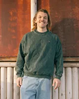 Buzo verde con efecto nevado, corte oversized y cuello redondo.