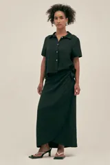 Camisa negra de manga corta con cuello camisero y botones de conchas naturales. El tejido lino-tencel es ideal para conseguir un look atemporal y natural.