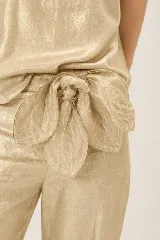 Faja de lino y algodón color dorado con diseño en forma de pétalos anudados en la cintura.
