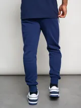 Pantalón de jogging azul marino de felpa con corte ajustado y banda lateral gris.