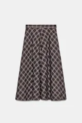Falda midi de tiro alto ZARA Woman Collection, con diseño evasé y estampado de cuadros en tonos oscuros con líneas rojas y blancas. Cuenta con cierre lateral con cremallera oculta.
