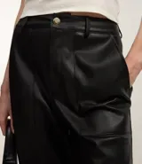 Pantalón negro de cuero sintético, corte recto, con bolsillos delanteros grandes y cierre con botón y cremallera.
