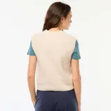 Chaleco de punto color beige con diseño trenzado, cuello redondo y sin mangas.