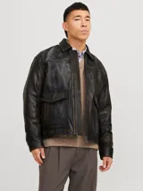 Campera de cuero marrón con cuello biker y cierre con cremallera. Confeccionada en cuero de cabra suave, naturalmente resistente al agua. Presenta mangas largas y bolsillos frontales con cierre de botón.