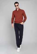 Sweater color ladrillo de tejido de punto, con cuello alto y cierre metálico a la mitad del pecho.