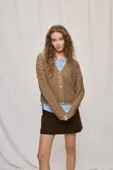 Cardigan de punto calado color tostado, con escote en V y cierre frontal de botones.