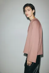 Buzo oversized de punto interlock pesado en color rosado, con cuello redondo y mangas largas amplias.