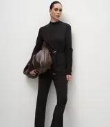Pantalón de corte flare confeccionado en tejido piquet, con cintura alta y ajuste ceñido en caderas y muslos que se ensancha suavemente desde la rodilla.