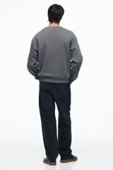 Buzo de tejido de mezcla de algodón de peso medio con interior cepillado suave. Modelo con cuello redondo ribeteado, hombros caídos y remate acanalado ancho en puños y bajo. Corte holgado.