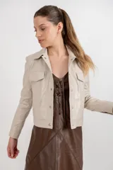 Campera estilo jeanera confeccionada en cuero ovino, con corte recto y largo a la cintura. Presenta cierre frontal con botones metálicos a presión, cuello clásico y dos bolsillos frontales con tapa.