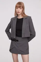 Blazer corto gris con cuello solapa y cierre con dos botones.
