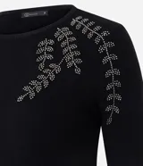 Suéter de punto en color negro con cuello redondo y mangas largas. Presenta un delicado bordado floral con pedrería en la zona de los hombros.