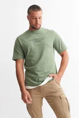Remera verde militar de algodón, con cuello redondo y estampado con texto en el pecho.