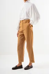 Pantalón de vestir color camel, tiro alto, corte recto y ancho, con puños doblados en el ruedo.