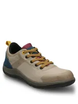 Championes de estilo outdoor en color beige, con detalles en azul, amarillo y bordó. Presentan un diseño impermeable con capellada textil transpirable, cierre de cordones y suela de goma de doble densidad para mayor amortiguación.