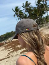 Gorra tipo dad hat color bordó con efecto lavado, con el logo de la marca bordado en hilo color crema en la parte frontal.