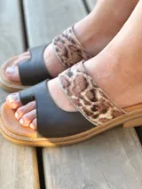 Sandalias bajas de cuero con dos tiras, una de cuero liso color gris y otra con estampado animal print.