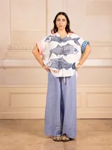 Pantalón palazzo con estampado de rayas verticales finas y detalle en el bajo. Tiene elástico en la cintura.