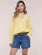 Cardigan de punto liviano color amarillo, con escote en V, mangas largas de hombros caídos, abotonadura frontal y bolsillos delanteros aplicados.