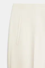 Pantalón de tiro alto y corte slim fit, de largo tobillero, color beige claro con costuras marcadas en la parte delantera.