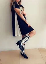 Vestido corto negro con panel lateral blanco, de corte holgado y mangas cortas con volados.