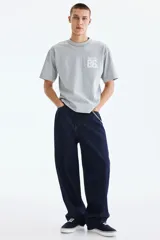 Remera gris melange de punto pesado de algodón, de corte holgado con hombros caídos, cuello redondo acanalado y bajo recto. Cuenta con un diseño estampado en el pecho con las inscripciones 'SOHONYC' y '86'.