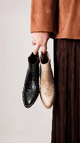 Botinetas de cuero color beige claro con combinación de texturas en el empeine, el talón y los laterales, taco cuadrado bajo de madera y cierre lateral.