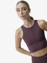 Top deportivo tipo crop top de sujeción media-alta, con cuello redondo y diseño de banda ancha en la parte inferior. Confeccionado en tejido técnico ligero y resistente, incluye copas extraíbles.