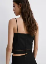 Top negro de corte recto y diseño corto, con escote recto, tirantes finos y detalles de costuras verticales con inserción semitransparente.