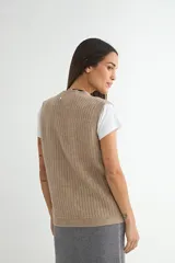 Chaleco de tejido de punto en color beige, con escote en V, cierre frontal con botones oscuros y dos bolsillos delanteros aplicados.