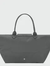 Bolso de mano tipo tote de la línea Le Pliage One de Longchamp, en color bordó. Presenta un diseño minimalista con cierre de cremallera superior, solapa con botón a presión y asas cortas de cuero.