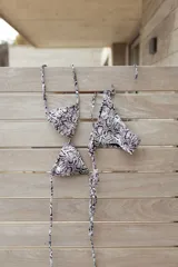 Bikini de dos piezas con estampado de piel de serpiente en blanco y negro. El top es de triángulos movibles para atar al cuello y espalda, con almohadillas desmontables. El bottom es vedetina con tiritas a los costados para atar y ajustar a la cadera.