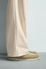 Mocasín destalonado de hombre, fabricado en piel con acabado serraje (gamuza), de horma redonda y suela a contraste con ligero tacón.