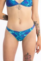 Bombacha de bikini tipo less, con diseño estampado que simula el reflejo del agua en tonos azules. Posee laterales ajustables y está completamente forrada.