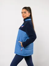 Parka de abrigo Umbro del Club Nacional de Football, con diseño bicolor que combina tejido polar blanco en la parte superior y tejido acolchado azul marino en la parte inferior. Cuenta con cierre frontal completo, cuello alto y bolsillos laterales.