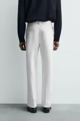 Pantalón chino de corte oversized confeccionado en tejido de algodón con estructura twill. Presenta bolsillos frontales, bolsillos traseros de vivo y cierre frontal con cremallera y gancho metálico oculto.
