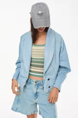 Chaqueta de jean corta confeccionada en 100% algodón, con silueta holgada, mangas raglán y solapas amplias.