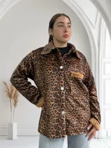 Sobrecamisa de pana con estampado animal print, cuello clásico y cierre con botones blancos.