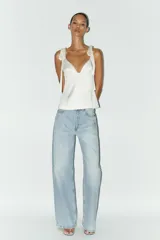 Top de satén rosado con escote en pico y tirantes finos que se atan con lazos.