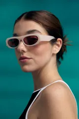 Lentes de sol con marco robusto de silueta rectangular, color blanco hueso o crema, y cristales tintados en tono rojizo/rosado.