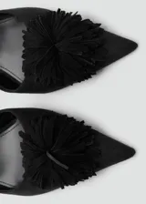 Zapato tipo kitten heel color negro, con punta fina y detalle de pompones en el empeine. Cuenta con una tira ajustable con hebilla en el tobillo.