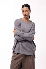 Sweater de punto con cuello redondo, mangas largas con hombros caídos y silueta relajada.