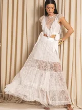 Conjunto de dos piezas negro compuesto por un top corto de encaje con volados y cuello redondo, y una falda larga de encaje con capas y transparencias.