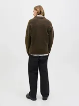 Cardigan de punto color marrón oscuro, con cuello tipo polo, cierre frontal con botones y un bolsillo aplicado en el pecho. Presenta mangas largas con hombros caídos y puños acanalados.