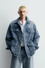 Parka de denim de algodón con efecto lavado, de color azul medio. Presenta cuello solapa, manga larga con puño abotonado, cierre frontal de botonadura oculta y cintura ajustable con cordón interior. Posee cuatro bolsillos utility de plastrón con solapa: dos en el pecho y dos en la cadera.