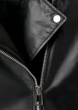 Chaqueta biker de piel de ovino color negro, con diseño recto, solapas con muesca, bolsillos laterales y frontal con cremallera, y forro interior de poliéster.