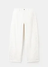 Jeans blancos de silueta balloon, tiro regular y largo standard, con detalles bordados sutiles en las perneras.