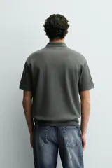 Polo regular fit color verde militar con textura acanalada vertical, cuello solapa con abertura frontal, manga corta y acabados en rib.