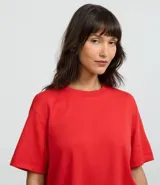 Remera de corte boxy con cuello redondo y mangas cortas. Confeccionada en algodón, presenta un diseño minimalista sin estampas con sisa caída.