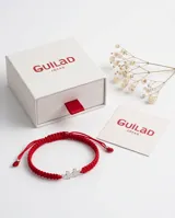 Pulsera de hilo rojo tejida en macramé con dijes de plata 925 en forma de niño y niña, con terminaciones ajustables decoradas con esferas de plata.